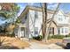 Charming townhouse with white siding and brick accents under a blue sky with mature tree and walkway at 12229 Savannah Garden Dr, Charlotte, NC 28273