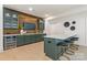 Home bar area boasts stylish green cabinetry, a wine fridge, and a large island with seating at 626 Concord Rd, Davidson, NC 28036