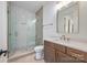 Bathroom with a walk-in shower, wood vanity, white countertop, and modern fixtures at 626 Concord Rd, Davidson, NC 28036