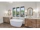 Elegant bathroom with a soaking tub, double vanities, and large windows offering natural light at 626 Concord Rd, Davidson, NC 28036