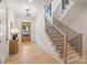 Bright entryway with wood floors, staircase with black railings, and modern light fixture at 626 Concord Rd, Davidson, NC 28036