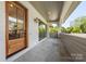 Inviting covered porch with gray tile flooring, a wood door, and paneled wood ceiling at 626 Concord Rd, Davidson, NC 28036