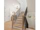 Staircase with light wood steps and a black metal railing leading to the second floor at 626 Concord Rd, Davidson, NC 28036