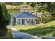Stairway leading to a modern boat dock with lifts on a serene lake, surrounded by lush greenery and a gazebo at 18304 Rosapenny Rd, Charlotte, NC 28278
