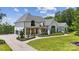 Charming home with a lush green lawn, porte cochere, and neatly manicured landscaping at 18304 Rosapenny Rd, Charlotte, NC 28278