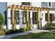 Charming front porch entrance with wooden pergola, striking black windows, and tastefully landscaped garden beds at 18304 Rosapenny Rd, Charlotte, NC 28278
