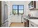 White kitchen features stainless appliances, white countertops, and large window for great lighting at 18304 Rosapenny Rd, Charlotte, NC 28278