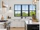 Bright kitchen features lots of natural light from the large picture window, modern appliances, and white cabinetry at 18304 Rosapenny Rd, Charlotte, NC 28278