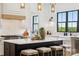 Bright kitchen features a large island, modern lighting and a view to the beautiful backyard at 18304 Rosapenny Rd, Charlotte, NC 28278