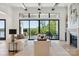 Bright living room featuring a wall of windows with backyard views and comfortable seating with a stone fireplace at 18304 Rosapenny Rd, Charlotte, NC 28278