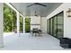 A covered patio with a fireplace, ceiling fans, and sliding glass doors offers indoor-outdoor living at 18304 Rosapenny Rd, Charlotte, NC 28278