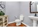 Elegant powder room features a pedestal sink, decorative mirror, and hardwood floors at 508 Cobbs Glen Ct, Rock Hill, SC 29732