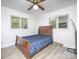 Bedroom with a wood sleigh bed and two windows for natural light at 3119 Hickory Hwy, Statesville, NC 28677
