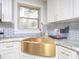 Bright kitchen featuring a gold sink, granite countertop, and subway tile backsplash at 3119 Hickory Hwy, Statesville, NC 28677