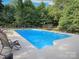 A beautiful in-ground pool is surrounded by a large concrete patio and mature shade trees at 3119 Hickory Hwy, Statesville, NC 28677