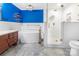 Modern bathroom featuring blue accent wall, a soaking tub, and glass-enclosed shower at 1628 Shannonhouse Dr, Charlotte, NC 28215