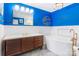 Stylish bathroom with a blue accent wall, dark wood vanity, soaking tub, and modern fixtures at 1628 Shannonhouse Dr, Charlotte, NC 28215