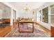 An airy dining room shows the hardwood flooring, modern light fixture, and view to living area at 1628 Shannonhouse Dr, Charlotte, NC 28215