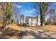 Back of a white brick home with a spacious yard and mature trees at 1628 Shannonhouse Dr, Charlotte, NC 28215