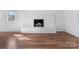 Living room space showcasing painted brick fireplace and wood-look flooring at 1628 Shannonhouse Dr, Charlotte, NC 28215