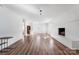 Bright living room featuring a painted brick fireplace and wood-look flooring at 1628 Shannonhouse Dr, Charlotte, NC 28215