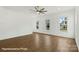 Bright living room featuring hardwood floors, modern ceiling fan, and natural light from large windows at 5860 Pittmon Ln, Kannapolis, NC 28081