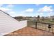 Charming rooftop deck with wood style tiling and wrought iron railing overlooking a serene residential landscape at 5860 Pittmon Ln, Kannapolis, NC 28081