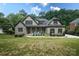 Charming stone and stucco home with a manicured lawn and inviting blue chairs on the front porch at 7582 Cottonwood Dr # 39, Denver, NC 28037