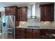 Modern kitchen with dark wood cabinets, granite counters, stainless steel appliances, and a tile backsplash at 7582 Cottonwood Dr # 39, Denver, NC 28037