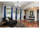 Bright living room featuring hardwood floors, large windows with blue curtains, and a cozy chaise lounge at 7582 Cottonwood Dr # 39, Denver, NC 28037