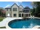 Captivating backyard showcasing a sparkling pool with a stone-accented hot tub and covered patio, perfect for outdoor entertainment at 7582 Cottonwood Dr # 39, Denver, NC 28037