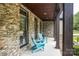 Covered porch with Adirondack chairs and stone exterior at 7582 Cottonwood Dr # 39, Denver, NC 28037