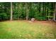 Large backyard with lush green grass, mature trees, and fire pit area, creating a serene outdoor space at 2518 Wellesbourne Ln, Sherrills Ford, NC 28673