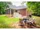 Brick home exterior with screened porch, outdoor seating area, and fire pit in a lush green backyard at 2518 Wellesbourne Ln, Sherrills Ford, NC 28673