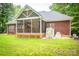 Spacious backyard with a screened porch, red brick home, well-maintained lawn, and outdoor grilling area at 2518 Wellesbourne Ln, Sherrills Ford, NC 28673