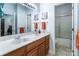 Bright bathroom featuring double sinks, vanity with framed mirror and shower at 2518 Wellesbourne Ln, Sherrills Ford, NC 28673