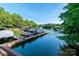 A dock with multiple boat slips along a tree lined lake shore beneath a clear blue sky at 2518 Wellesbourne Ln, Sherrills Ford, NC 28673