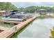 Scenic view of boat dock featuring covered boats on the water with gazebos and lush green trees along the shoreline at 2518 Wellesbourne Ln, Sherrills Ford, NC 28673