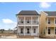 Charming two-story home featuring double balconies, white pillars, black railings, and a welcoming front entrance at 5830 Pittmon Ln, Kannapolis, NC 28081