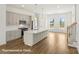 Spacious kitchen with a large island, stainless steel appliances, and seamless connection to the stairs at 5830 Pittmon Ln, Kannapolis, NC 28081