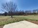 Expansive backyard featuring a large grassy area and beautiful mature trees creating a park-like setting at 9609 Stokes Ferry Rd, Gold Hill, NC 28071