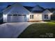 Charming single-story home with a two-car garage, manicured lawn, and modern white siding at 9609 Stokes Ferry Rd, Gold Hill, NC 28071