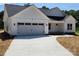 Charming single-story home with a two-car garage, manicured lawn, and modern white siding at 9609 Stokes Ferry Rd, Gold Hill, NC 28071