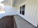 Inviting covered entry of a modern home with brick accents and vertical white siding at 9609 Stokes Ferry Rd, Gold Hill, NC 28071