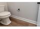 A close up of a white toilet and paper holder on wood-look flooring at 9609 Stokes Ferry Rd, Gold Hill, NC 28071