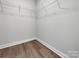 Empty walk-in closet with shelves and wood-look flooring at 9609 Stokes Ferry Rd, Gold Hill, NC 28071