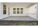 A covered back porch with concrete flooring provides a relaxing outdoor space with a view of the backyard at 121 Clawton Loop, Mooresville, NC 28115