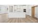 Modern, all-white kitchen featuring a center island, white cabinets, and stainless steel appliances at 121 Clawton Loop, Mooresville, NC 28115