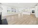 Spacious living room seamlessly connecting to a modern, all-white kitchen; a perfect space for entertaining at 121 Clawton Loop, Mooresville, NC 28115