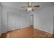 A simple bedroom featuring wood-look floors, bi-fold closet doors, and a classic ceiling fan at 3338 Passmore Rd, Rock Hill, SC 29730